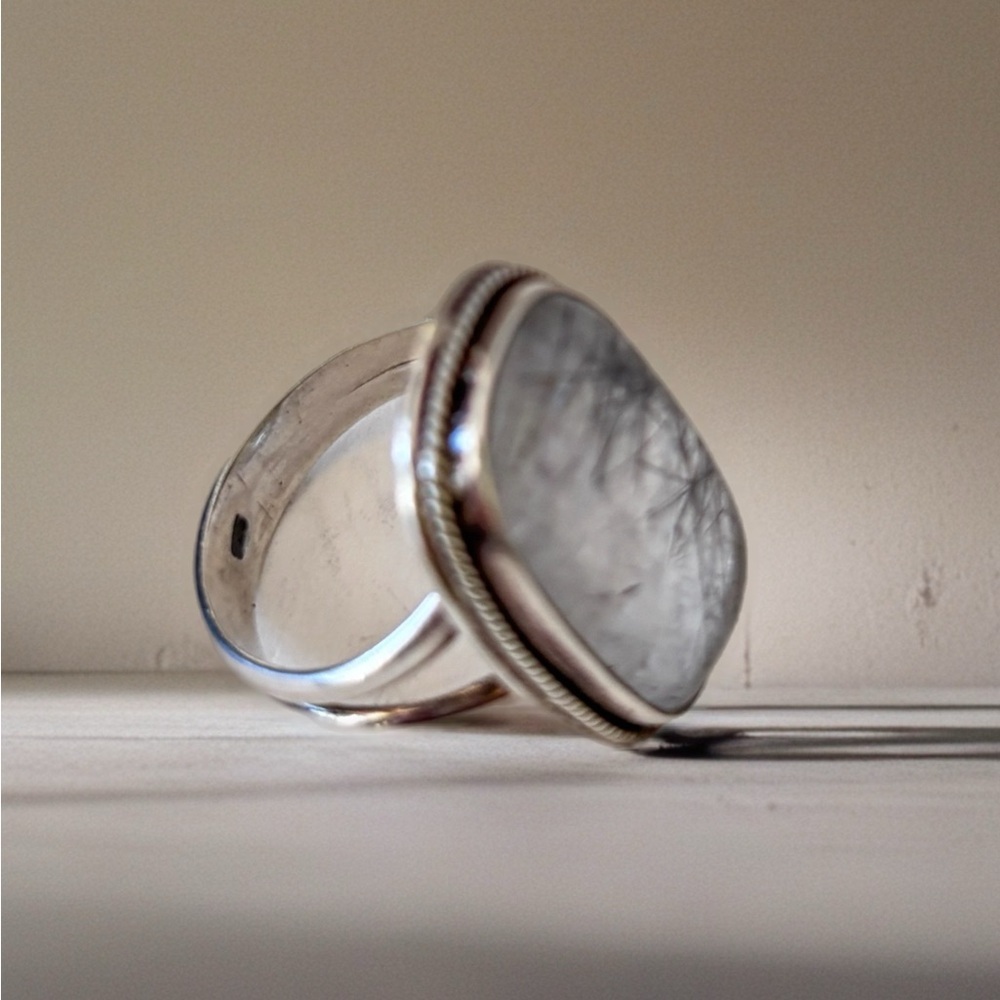 This piece is a black rutilated quartz ring set in sterling silver. Size 8